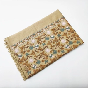 Detailed embroidery of brown leaves and pink flowers on thick cashmere-feel scarf with tassels