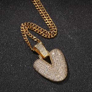 Gros plan du pendentif cœur en or serti de zircons blancs sur une chaîne cubaine
