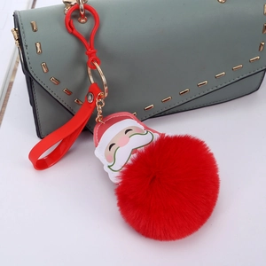 Christmas Santa pompom keychain with red plush ball and silicone strap on a handbag