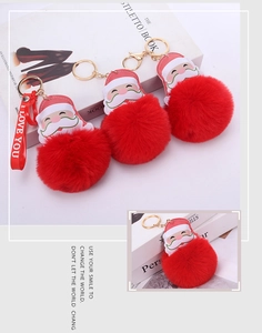 Detail of red plush ball keychain with Santa leather charm and golden metal hardware
