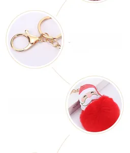 Detail of red plush Christmas Santa keychain with gold plated clasp and faux leather charm