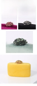 Close-up of luxury velvet evening clutch with crystal-encrusted floral clasp detail