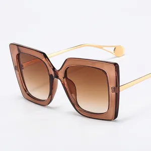 Fashionable oversized square sunglasses with transparent brown frames and gold metal temples