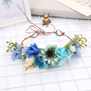Detailed view of floral bridal crown with blue and green faux flowers on a twig base