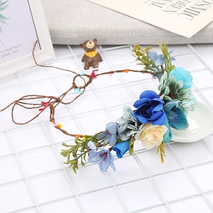 Detailed view of floral crown with blue and cream silk flowers on flexible vine base