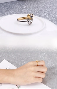 Detail der minimalistischen Titanstahl-Herzringe mit funkelndem Zirkon in Gold und Silber