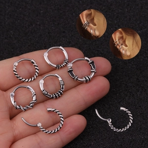 Macro detail of silver twisted and bone pattern ear hoops with model wearing demonstration