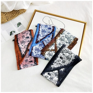 Detail of four silk scarves with tropical elephant prints and palm tree patterns