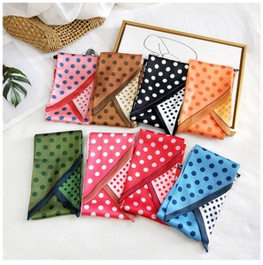 Detailed flat lay of colorful polka dot scarves folded neatly on a white fabric background