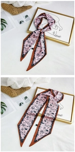 Detail of pink silk scarf with animal print and brown edges on aesthetic background