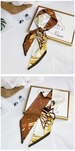 Detail view of brown and beige silk scarf with classic chain and horse carriage patterns