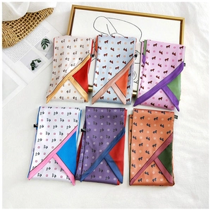 Close-up of six assorted silk scarves with elegant horse carriage patterns in various colors