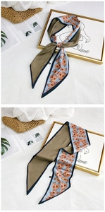 Close-up of blue floral silk scarf with beige geometric patterns and navy border detailing
