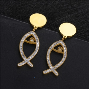 Elegant gold fish drop earrings with white crystal rhinestones on a dark textured background
