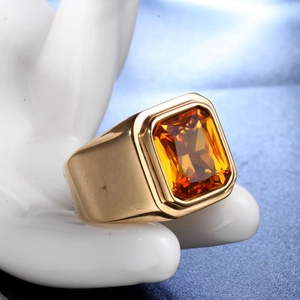 Vue macro d'une bague dorée avec une grande pierre ambre rectangulaire sur un modèle de main
