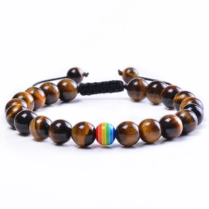 Vue macro de perles d'oeil de tigre et perle arc-en-ciel sur bracelet tressé ajustable