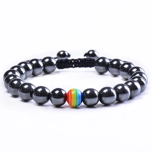 Détail d'un bracelet ajustable en perles de lave avec une perle arc-en-ciel centrale