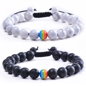 Détail de bracelets en turquoise blanche et pierre de lave noire avec perle arc-en-ciel