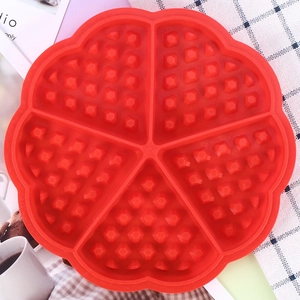 Macro detail of red flower-shaped silicone waffle mold with grid texture for baking