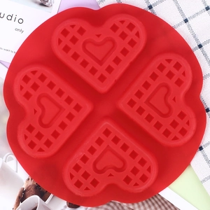 Detail of red silicone waffle mold with four heart-shaped grids for baking and desserts