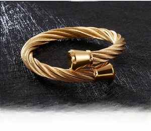 Macro shot of gold twisted rope bangle showing the detailed woven texture and polished ends
