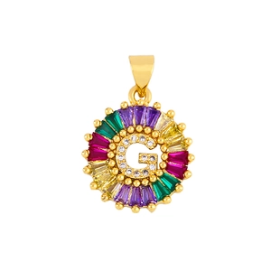 Close-up of golden letter G pendant with colorful cubic zirconia and micro-set crystals