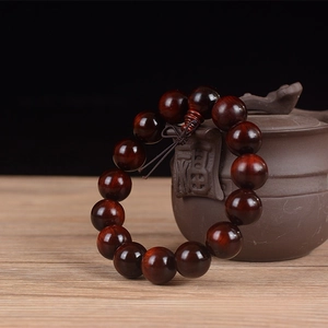 Close-up of 15mm Sandalwood beads with fine drilling and a traditional Chinese knot
