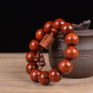 Macro shot of 18mm red sandalwood prayer beads with square plaque and gourd accessories