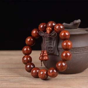 Macro detail of sandalwood beads with golden star textures and traditional knot tassel