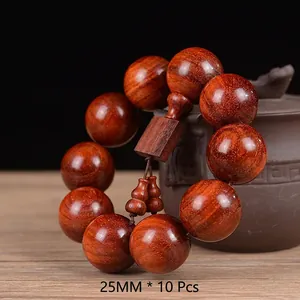 Macro detail of 25mm sandalwood beads with golden star patterns and wooden pendant