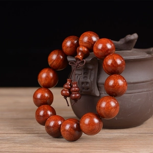 Detail of 18mm red sandalwood beads with polished finish and decorative gourd pendant