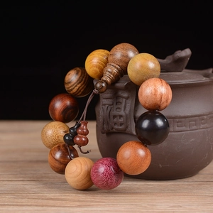 Detailed close-up of 20mm mixed wood prayer beads with decorative gourd pendant