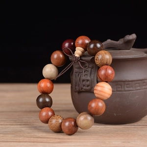 Macro detail of mixed hardwood beads with natural grain on a ceramic teapot background