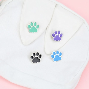 Kawaii cat paw enamel pin badges set in green, purple, black, and blue on canvas bag