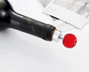 Close-up of a red crystal ball wine stopper with sparkling rhinestones on a bottle