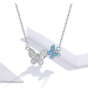 Detailed view of silver butterfly pendant with blue crystals and hollow wing design