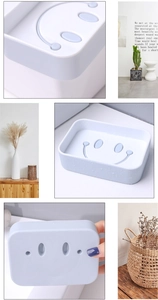 Detail view of light blue dual-layer soap dish with smiley face drainage holes