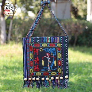 Detail of ethnic embroidered shoulder bag with colorful tassels and wooden beads