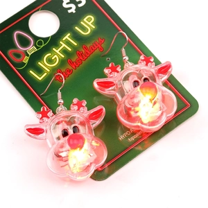 Macro view of glowing LED reindeer Christmas earrings with warm yellow light nose