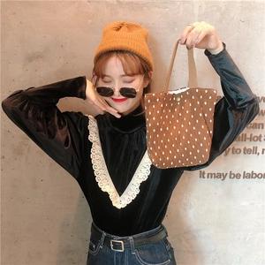 Mini borsa a mano marrone a pois con chiusura a scatto mostrata in stile alla moda