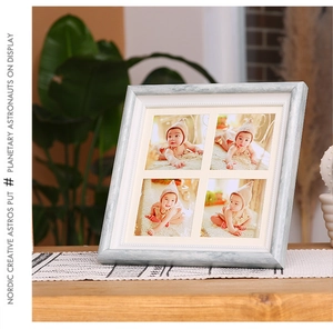 Detail of grey wood grain 4-opening photo frame with white mat for tabletop display