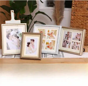 Detail of four European-style carved photo frames in gold and silver on a wooden surface
