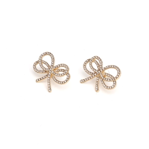 Detailed view of golden bow earrings with sparkling rhinestones and micro-inlay