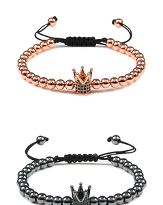 Detail showing rose gold and gunmetal crown bracelets with hand-woven adjustable cords