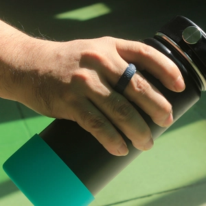 Detail of dark blue silicone sports ring with geometric pattern worn on hand while training
