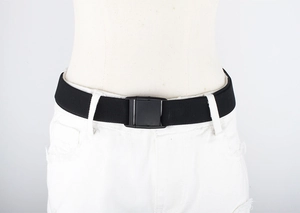 Detail of black elastic belt with square plastic buckle on white pants