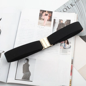Detail of a black elastic waist belt with a gold metal buckle on a fashion magazine