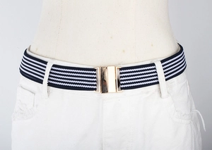 Close-up of blue and white striped elastic belt with a golden metal buckle on white pants