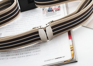 Detail view of tri-color elastic woven belt with metal buckle on a fashion magazine