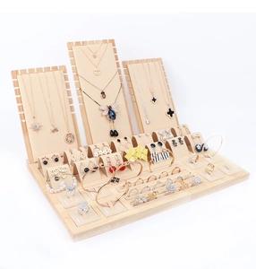 Detailed view of wood and beige velvet jewelry display set with slots for rings and necklaces